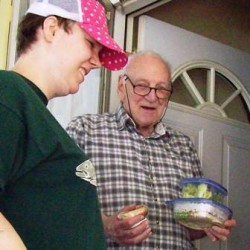 Volunteer Gloria delivering meal to Meals on Wheels client.